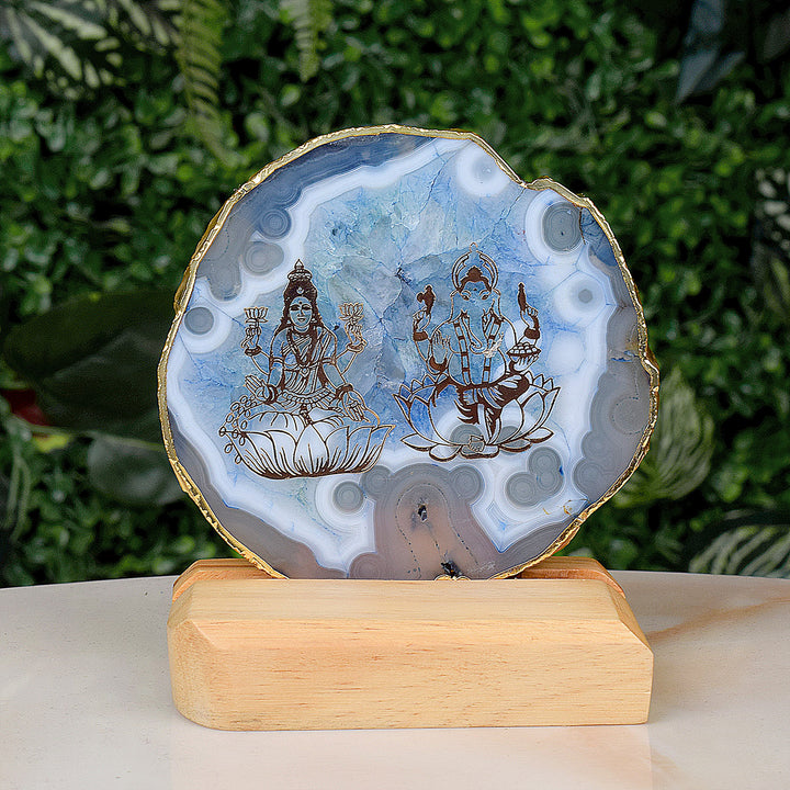 Agate stone stand featuring intricately carved Laxmi and Ganesha idols, mounted on a polished natural agate base for spiritual and decorative use. Indiaβs Largest Pooja Accessories Brand β www.satvikstore.in