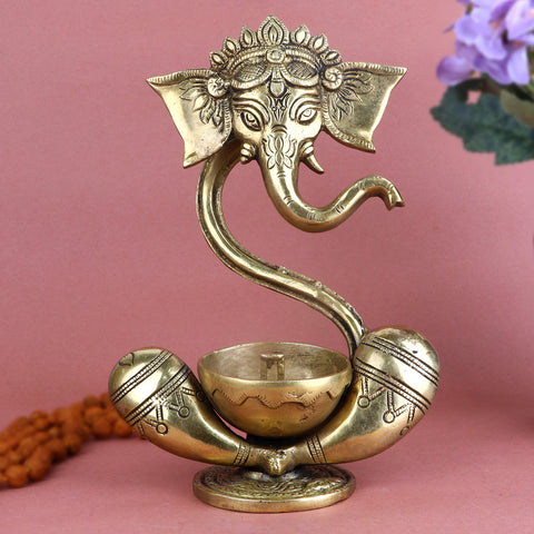 Alluring Brass Ganesh Akhand Diya featuring a detailed idol of Lord Ganesha with an attached eternal flame oil chamber, perfect for long-lasting spiritual glow during pooja, festivals, and daily worship. Indiaβs Largest Pooja Accessories Brand β www.satvikstore.in