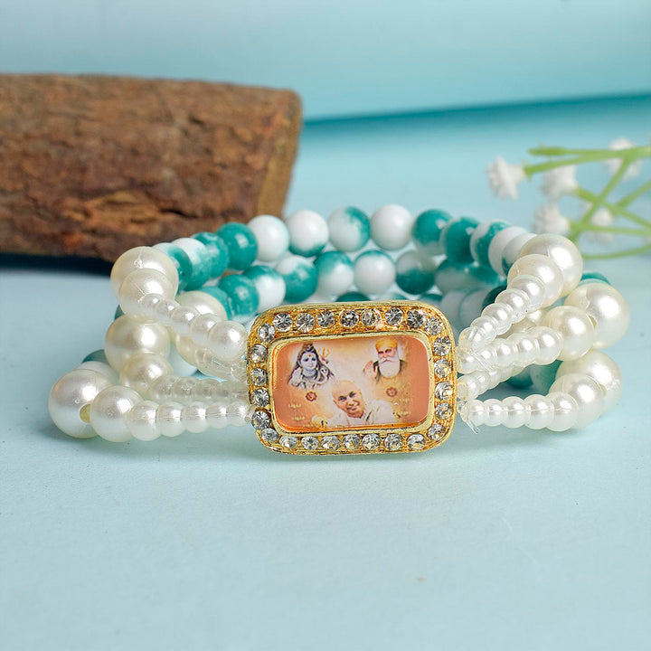 Bluish Green & White Marble Four Layer Guruji Swaroop Bracelet featuring tranquil bluish green beads and marble effect white beads with Jai Guruji Swaroop β perfect for spiritual wear, festive gifting, and daily devotion. Indiaβs Largest Pooja Accessories Brand β www.satvikstore.in