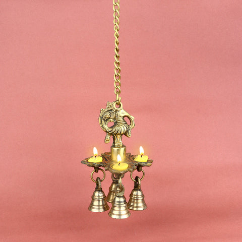 Intricately designed Brass Chaumukh Peacock Hanging Diya featuring four-faced oil lamps and detailed peacock motifs, adorned with hanging bellsβperfect for temples, home mandirs, or festive decorations. Indiaβs Largest Pooja Accessories Brand β www.satvikstore.in