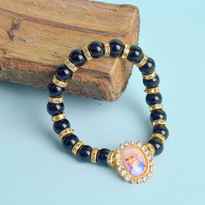 Shop the Black Shiny Beads with Golden Studs Single Layer Guruji Swaroop Bracelet at satvikstore.in. A luxurious spiritual bracelet featuring glossy black beads with sparkling golden studs and Jai Guruji Swaroop. Perfect for daily wear, meditation, or gifting. Elevate your style with India’s Largest Pooja Accessories Brand.