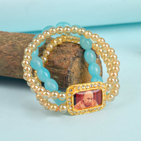 Golden Clear & Baby Blue Triple Layer Guruji Swaroop Bracelet featuring sparkling golden clear beads with a serene baby blue middle layer and Jai Guruji Swaroop β perfect for spiritual wear, meditation, and gifting. Indiaβs Largest Pooja Accessories Brand β www.satvikstore.in