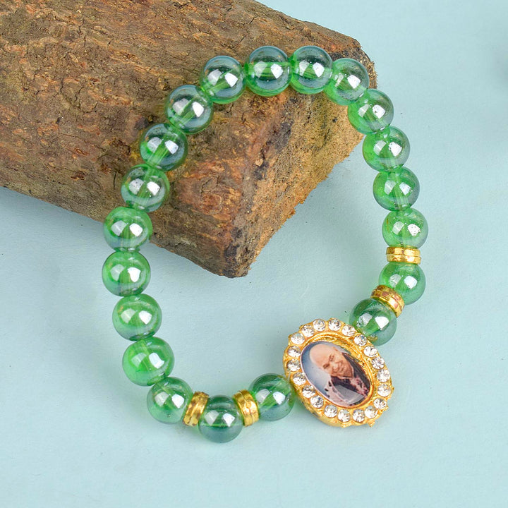 Green Shiny Beads Single Layer Guruji Swaroop Bracelet featuring dazzling green beads and Jai Guruji Swaroop β perfect for minimalist spiritual wear, meditation, and gifting. Indiaβs Largest Pooja Accessories Brand β www.satvikstore.in