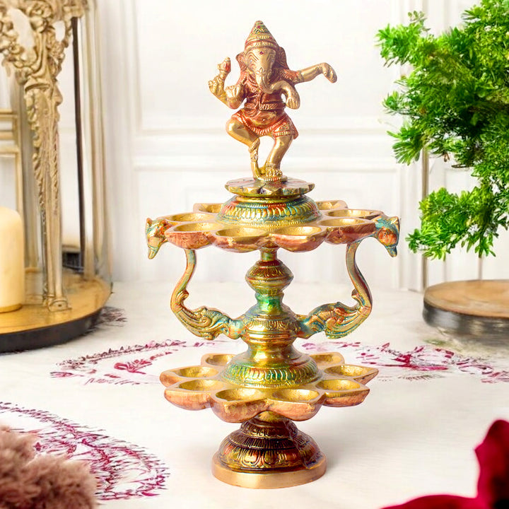 Handcrafted brass 21-wick Ganesha Diya with 2-step aarti design, featuring a majestic Lord Ganesha idol and multiple flames for grand pooja ceremonies. Indiaβs Largest Pooja Accessories Brand β www.satvikstore.in