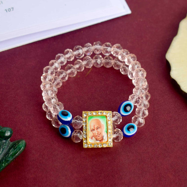 Jai Guruji Swaroop Bracelet with pink beads and Evil Eye charm, handcrafted for divine energy and spiritual protection. Indiaβs Largest Pooja Accessories Brand β www.satvikstore.in
