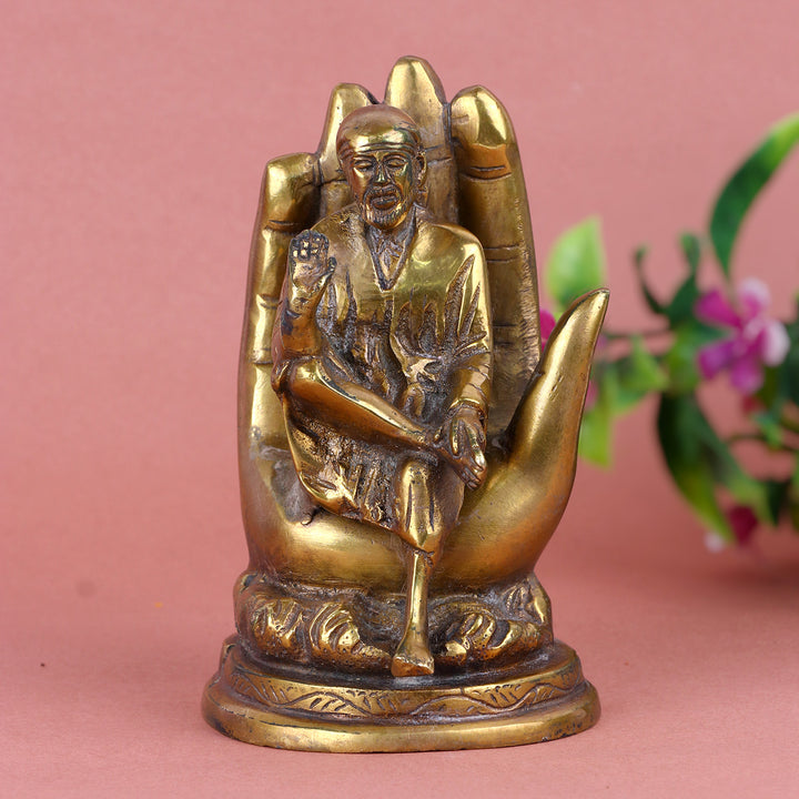 6.4 Inch Pure Brass Shirdi Sai on Hand Statue β Exquisitely Handcrafted Idol Depicting Shirdi Sai Baba Resting on a Divine Hand, Symbolizing Protection, Blessings, and Faith for Home and Temple Decor. No.1 Brass Idol Store www.satvikstore.in