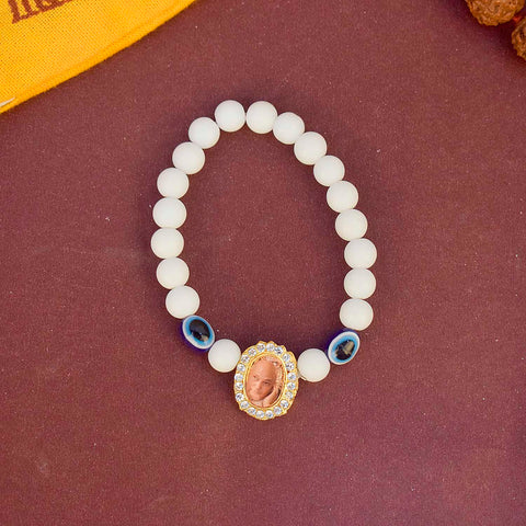 White Beads with Evil Eye Single Layer Guruji Swaroop Bracelet featuring pure white beads accented with a blue evil eye bead and Jai Guruji Swaroop β perfect for spiritual wear, protection, and gifting. Indiaβs Largest Pooja Accessories Brand β www.satvikstore.in