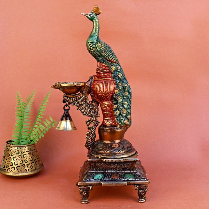 Satvik Stores Presents Brass Peacock Diya Stand. Any festive occasion will be made wonderfully auspicious by the grace and beauty of the Peacock Brass Handcrafted Hanging Diya. Given that it was made by hand, the piece's abnormalities and flaws only serve to enhance Diya's allure and charisma.