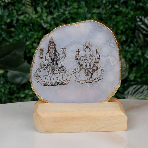 Agate stone stand featuring intricate hand-painted images of Goddess Laxmi and Lord Ganesha, symbolizing prosperity, wealth, and divine blessings, placed elegantly on a wooden base for spiritual home decor. Indiaβs Largest Pooja Accessories Brand β www.satvikstore.in