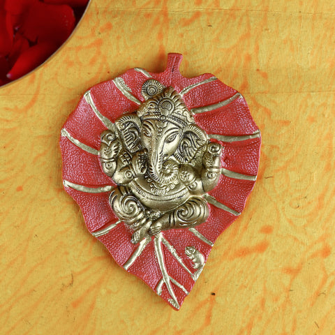 Red leaf-shaped wall hanging featuring a beautifully detailed idol of Lord Ganesh, perfect for spiritual and festive home decor. Indiaβs Largest Pooja Accessories Brand β www.satvikstore.in